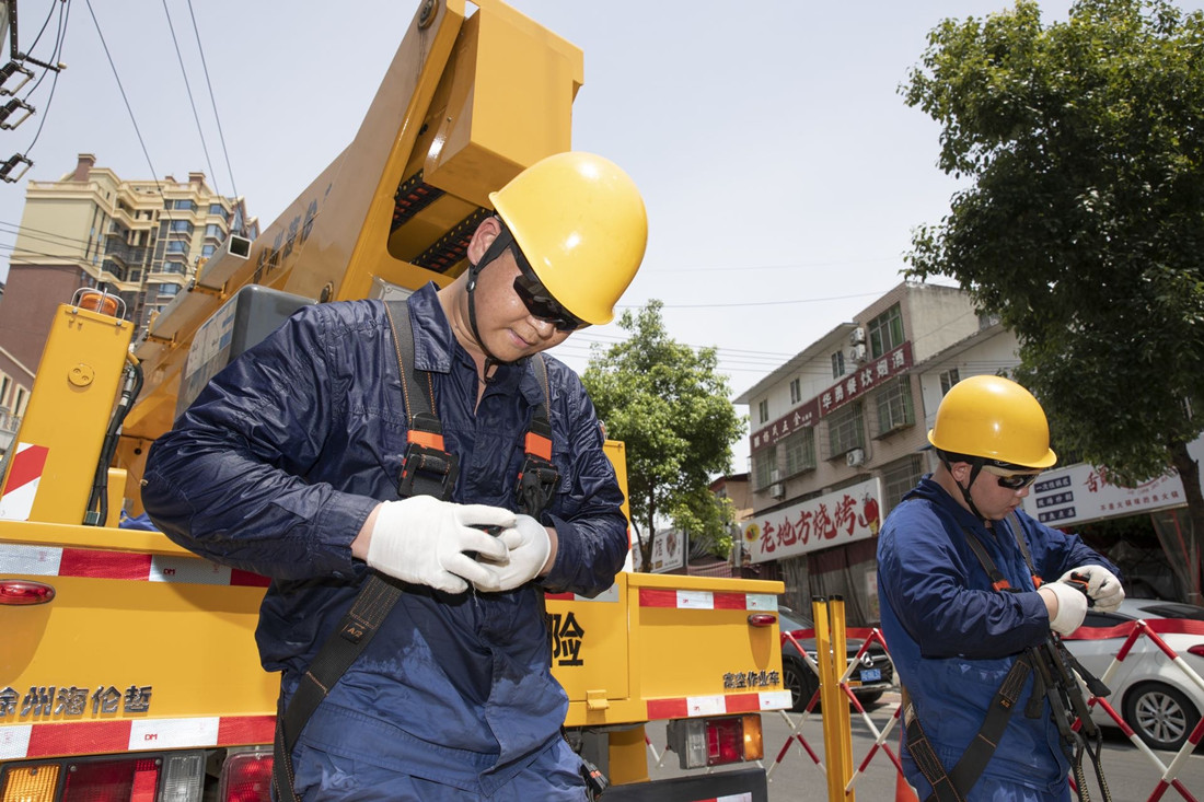 國網(wǎng)綿陽供電公司電力工人結(jié)束帶電作業(yè)，汗水浸透了工裝_副本.jpg