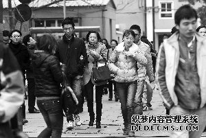 昨天，在國考北京電子科技職業(yè)學(xué)院汽車工程學(xué)院考點(diǎn)，寒風(fēng)中考生們走出考場。晨報(bào)記者 李木易/攝